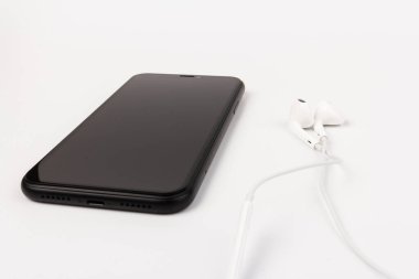 Kulaklık ve telefon beyaz arka planda. Müzik dinlemeye hazır mısın?