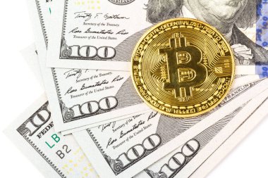 100 dolarlık banknotların üstüne altın bitcoin. İş, para, kripto para birimi kavramı.