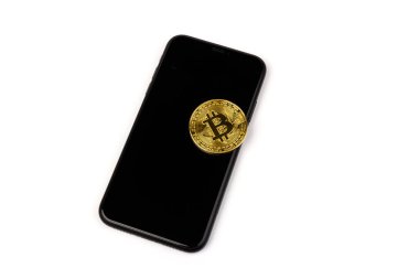 Beyaz arka planda siyah telefonu olan altın bitcoin. İş, para, kripto para birimi kavramı.