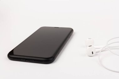 Kulaklık ve telefon beyaz arka planda. Müzik dinlemeye hazır mısın?