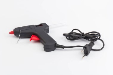 Sıcak eritilmiş silah, inşaat aletleri. Beyaz arkaplanda tutkal tabancası ve çubuklar