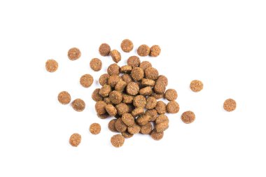 Kedi maması. Kuru kahverengi kedi maması yakın plan beyaz arka plana saçılmıştır.