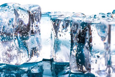 Erimiş buz küpleri ve damlalar. Buz küpleri ve su damlaları mavi ve beyaz arkaplanı kapatır.