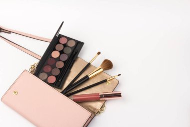 Beyaz arka planda kozmetik çantalı makyaj ürünleri. Güzellik konsepti: beyazın kozmetik üst görünümü. İş yeri, kozmetik çanta.