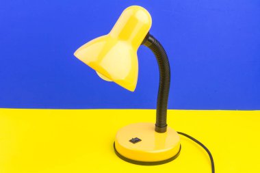 Sarı masa lambası mavi ve sarı arka planda izole edilmiş. Gündüz ve gece konsepti