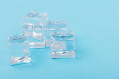 Şeffaf buz küpleri piramidi. Buz küpleri mavi arka planda kapanıyor. Metin için boşluk