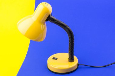 Sarı masa lambası mavi ve sarı arka planda izole edilmiş. Gündüz ve gece konsepti