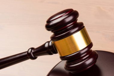 Kahverengi ahşap jüri tokmağı masaya yakın çekimde. Tahta masa. Mesaj için yer var. Hukuk ve Adalet teması