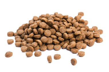 Kedi maması. Kuru kahverengi kedi maması yakın plan beyaz arka plana saçılmıştır.