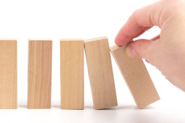 Sıranın çöküşü arasında ayakta duran ahşap blok, iş kavramı hayatta kalabilme ya da yıkımdan baskın konsept