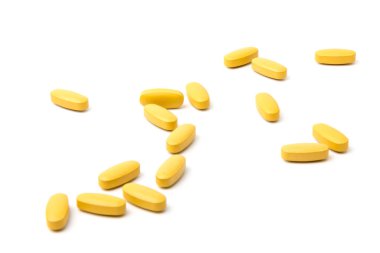 Sarı Multivitamin ve sünnet hapları, yakın plan beyaz zemin üzerine besin takviyesi