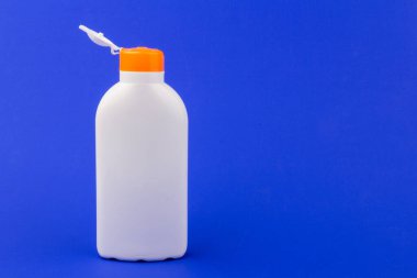 Mavi arka planda güneş kremi şişesi. Sağlık kavramları ve cilt bakımı