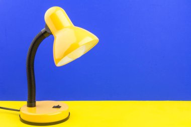 Sarı masa lambası mavi ve sarı arka planda izole edilmiş. Gündüz ve gece konsepti