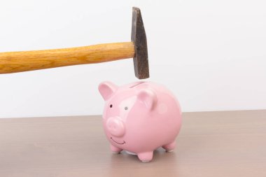 Ahşap arka planda çekiçli domuz kumbarası, mesaj için yer. Finans, tasarruf. İş başarıya ve emeklilik konsepti için biriktirmeye