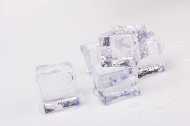 Şeffaf buz küpleri piramidi. Buz küpleri gri arka planda kapanıyor. Metin için boşluk