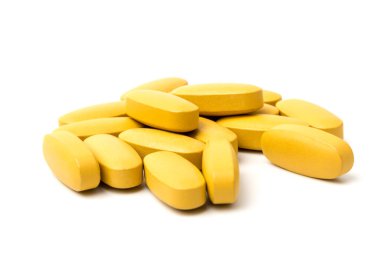 Sarı Multivitamin ve sünnet hapları, yakın plan beyaz zemin üzerine besin takviyesi