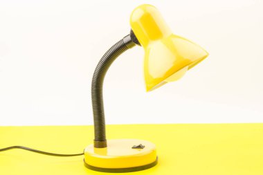 Sarı masa lambası sarı arka planda izole edilmiş. Gündüz ve gece konsepti