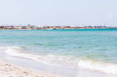 Yaz plajı ve deniz. Güneşli bir günde açık deniz manzaralı, gök mavisi bir sahil. Yaz tatili kavramı