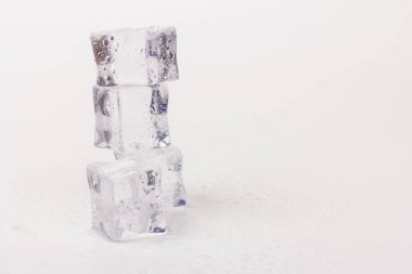 Şeffaf buz küpleri piramidi. Buz küpleri gri arka planda kapanıyor. Metin için boşluk