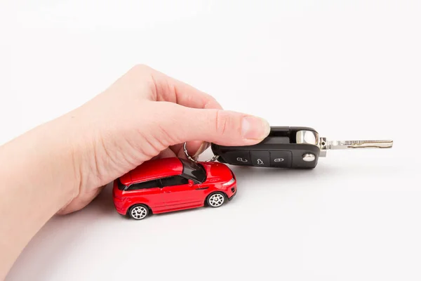 Red car and key in hand. Concept of the automobile loan, saving money for car, trade car for cash, the concept of Finance.