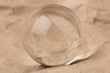 Kırışmış kağıdın üzerinde cam top, cam küre