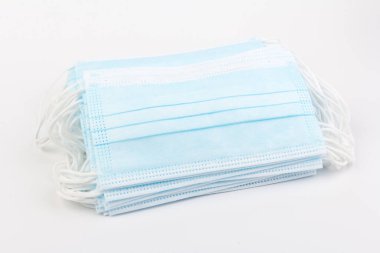 Mavi tıbbi maske beyaz arka planda izole edilmiş. Kirliliğe, virüse, gribe ve koronavirüse karşı yüz maskesi koruması. Sağlık ve Cerrahi Konsept.