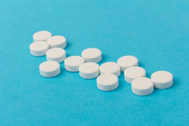 Mavi arka planda bir sürü hap. Eczacılık konsepti: mavi arka planda haplar üst görünüm