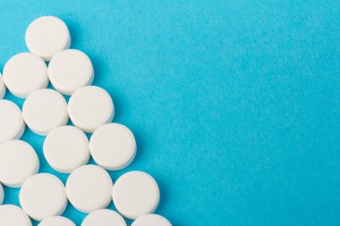 Mavi arka planda bir sürü hap. Eczacılık konsepti: mavi arka planda haplar üst görünüm