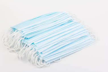 Mavi tıbbi maske beyaz arka planda izole edilmiş. Kirliliğe, virüse, gribe ve koronavirüse karşı yüz maskesi koruması. Sağlık ve Cerrahi Konsept.