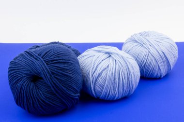 açık mavi ve koyu mavi iplik topları mavi ve beyaz arka planda. Doğal yün. Örgü örüyorum. arkaplan