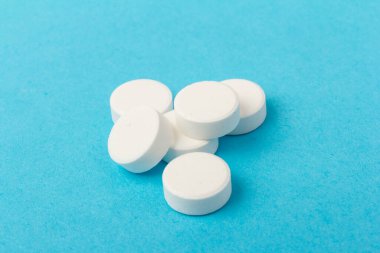 Mavi arka planda bir sürü hap. Eczacılık konsepti: mavi arka planda haplar üst görünüm