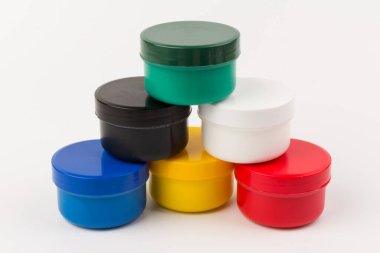 Beyaz arka planda çocukların yaratıcılığı için farklı renklerde boyalı kapalı plastik kavanozlar. Çizim için malzemeler, yaratıcılık, erken çocukluk gelişimi.