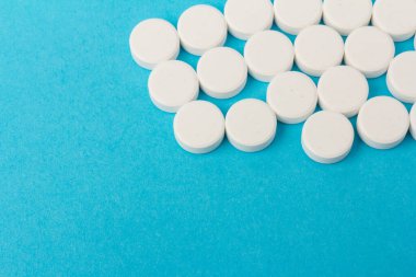 Mavi arka planda bir sürü hap. Eczacılık konsepti: mavi arka planda haplar üst görünüm