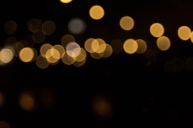 Siyah arka bahçenin önünde ateşten buğulanmış kıvılcımlar. Noel ve yeni yıl tatili konsepti. Odaklanmamış çelenk ışıkları, Bokeh etkisi. 