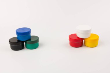 Beyaz arka planda çocukların yaratıcılığı için farklı renklerde boyalı kapalı plastik kavanozlar. Çizim için malzemeler, yaratıcılık, erken çocukluk gelişimi.