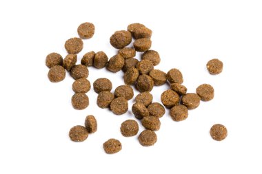 Kedi maması. Kuru kahverengi kedi maması yakın plan beyaz arka plana saçılmıştır.