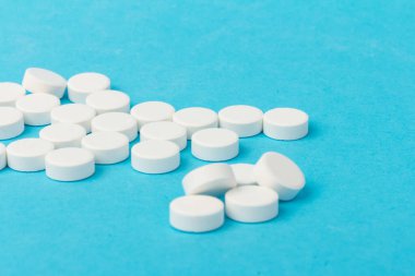 Mavi arka planda bir sürü hap. Eczacılık konsepti: mavi arka planda haplar üst görünüm