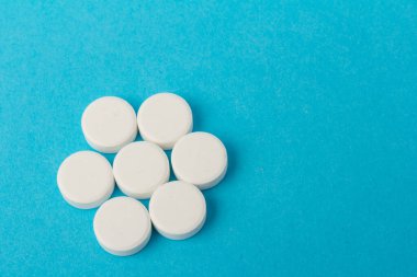 Mavi arka planda bir sürü hap. Eczacılık konsepti: mavi arka planda haplar üst görünüm