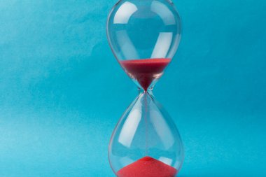 Kum saati ampulleri arasında akan ve bir geri sayım bitiş tarihine kadar geçen zamanı ölçen mavi arka planda fotokopi alanı olan bir kum..