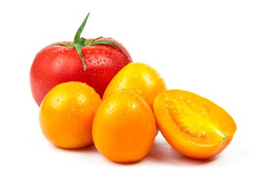 Olgun taze kırmızı ve sarı renkli organik domatesler. Beyaz arka planda su damlaları var.