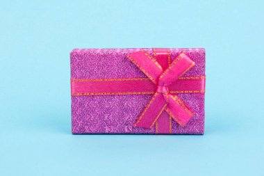 Mavi arka planda yay ve kurdeleli hediye kutusu. Hediye, sürpriz, ödül ikonu. Noel, doğum günü, tatil konsepti.