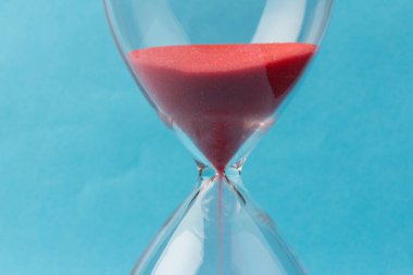 Kum saati ampulleri arasında akan ve bir geri sayım bitiş tarihine kadar geçen zamanı ölçen mavi arka planda fotokopi alanı olan bir kum..