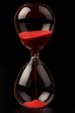 Kırmızı Kum, bir kum saatinin ampullerinin içinden geçerek bir geri sayım bitimine kadar geçen zamanı ölçüyor, fotokopi alanı olan siyah bir arkaplanda..