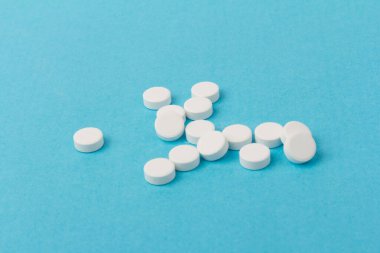 Mavi arka planda bir sürü hap. Eczacılık konsepti: mavi arka planda haplar üst görünüm