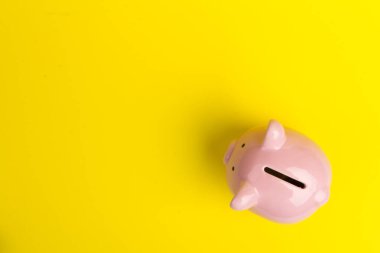 Sarı arka planda domuz kumbarası, mesaj için yer. Finans, tasarruf.