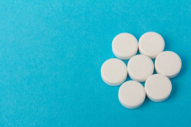 Mavi arka planda bir sürü hap. Eczacılık konsepti: mavi arka planda haplar üst görünüm