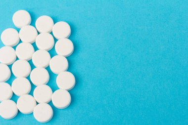 Mavi arka planda bir sürü hap. Eczacılık konsepti: mavi arka planda haplar üst görünüm