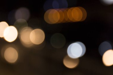 Siyah arka bahçenin önünde ateşten buğulanmış kıvılcımlar. Noel ve yeni yıl tatili konsepti. Odaklanmamış çelenk ışıkları, Bokeh etkisi. 