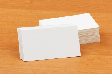 Tahta bir yüzey üzerinde beyaz, boş kartvizitler yığını