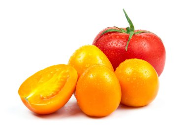 Olgun taze kırmızı ve sarı renkli organik domatesler. Beyaz arka planda su damlaları var.